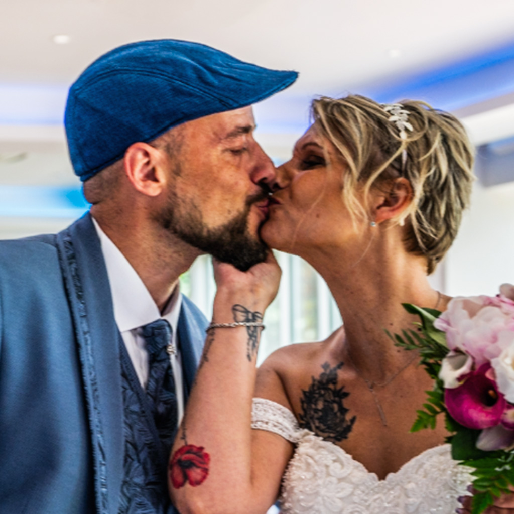 Photographie d'un couple en mariage qui s'embrassent
