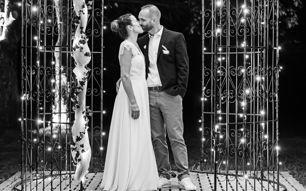 Photo de prestation de mariage. Un couple s'embrasse sous un dôme romantique