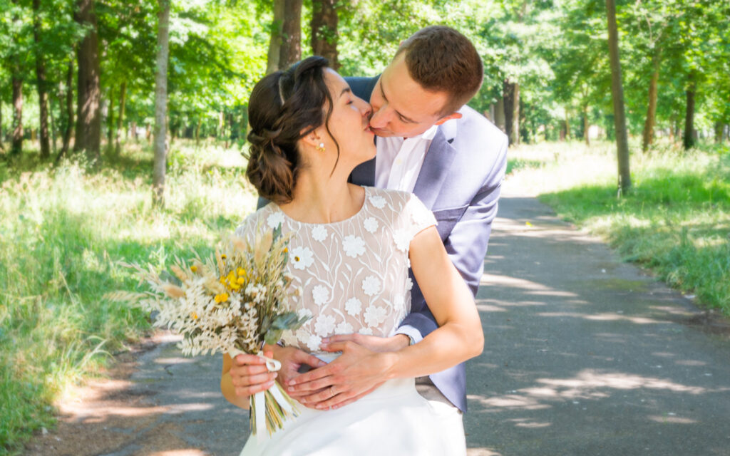 un couple marié qui s'embrassent dans une ambiance romantique printemps dans un style classique